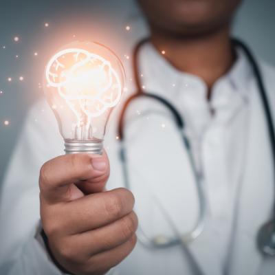 Doctor holding lit light bulb with glowing brain graphic