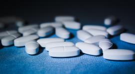 white oval pills on blue mat