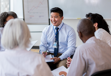 A group of 5 medical people sitting in a circle