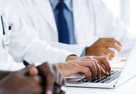 Medical hands typing on a laptop