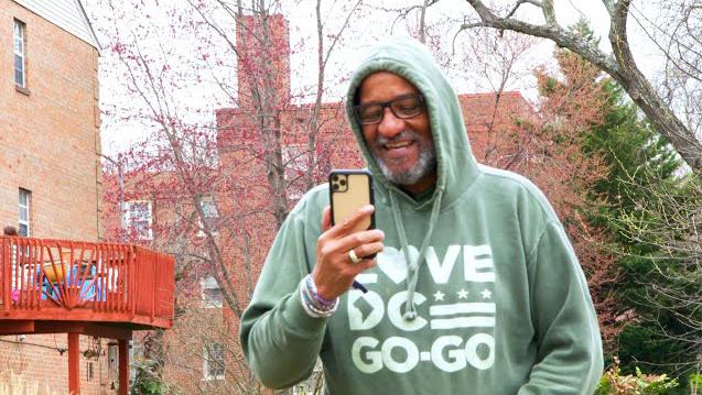 Watch on YouTube: Image of Lamont Mitchell walking outside, smiling, speaking on his cell phone to his care team
