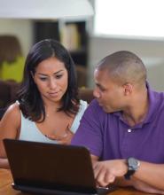 Decorative Health Insurance Marketplace Quality Initiatives Icon - a woman and a man looking at computer screen together 